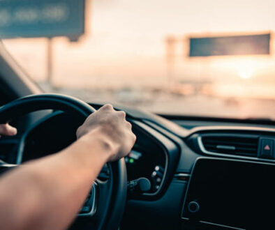 Close-up - Hand of man driving car on the road.